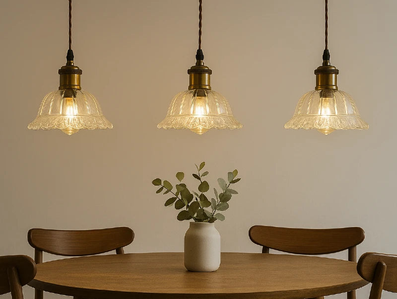 שלוש מנורות תלייה מעל שולחן אוכל