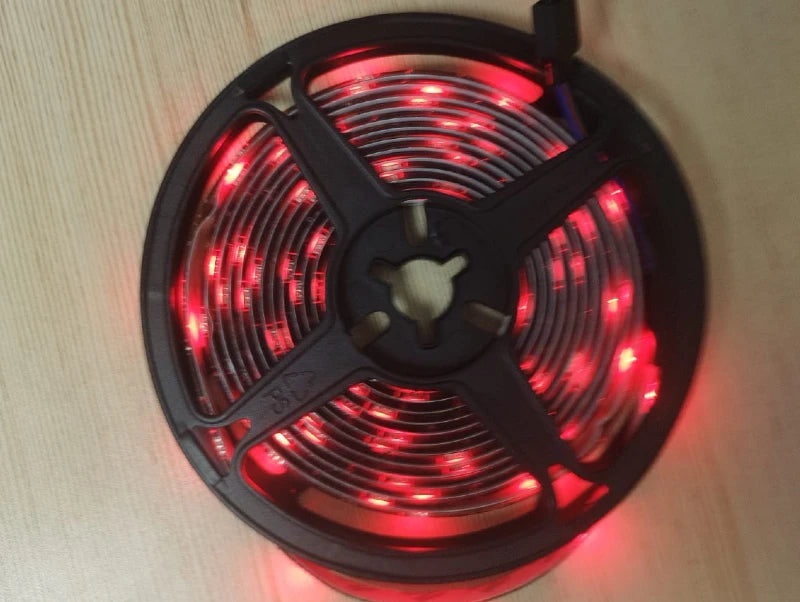 גליל פס לד גמיש מואר באור אדום על משטח בהיר