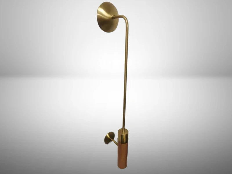 מנורת קיר BRASS POLE במבט זוויתי, עם זרוע ארוכה ודקה, בסיס קיר עגול ושילוב של פליז ועץ על רקע בהיר.
