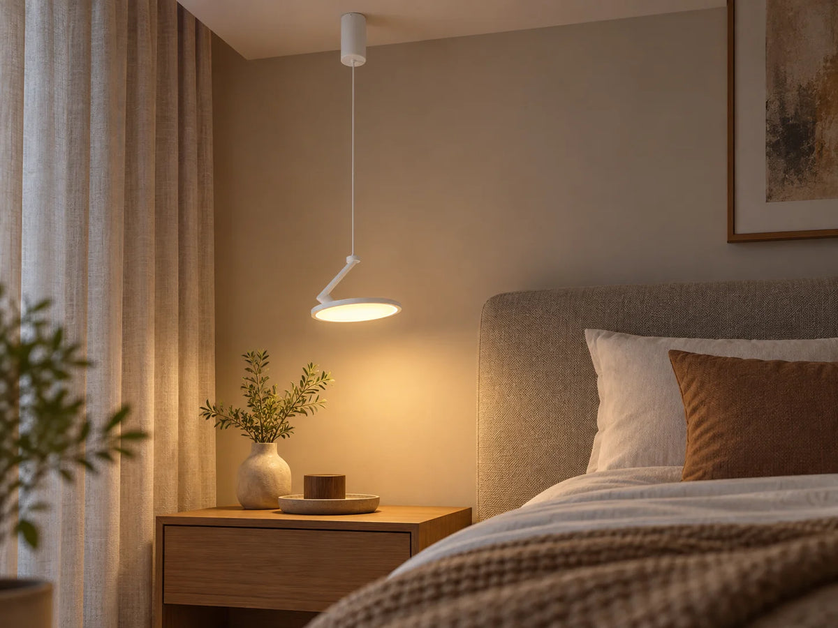 מנורת תלייה לבנה ZARA עם זרוע מתכווננת, מותקנת בתקרת חדר שינה מודרני מעל שידת לילה.