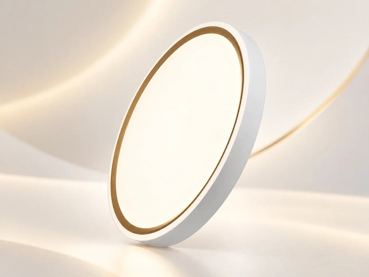 גוף תאורה צמוד תקרה OMEGA RING CCT, עגול ושטוח, עם גימור לבן ופס זהוב עדין סביב שולי הפלטה המוארת.