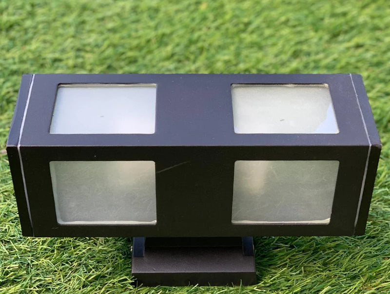 מנורה שחורה לתאורת גינה וחצר על רקע דשא