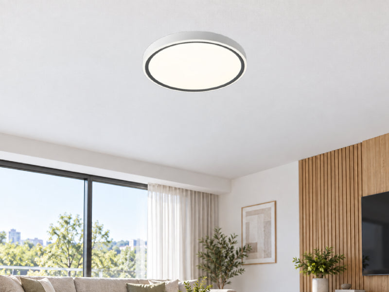 גוף תאורה צמוד תקרה OMEGA RING CCT עגול לבן עם מסגרת שחורה, מותקן בסלון מודרני.