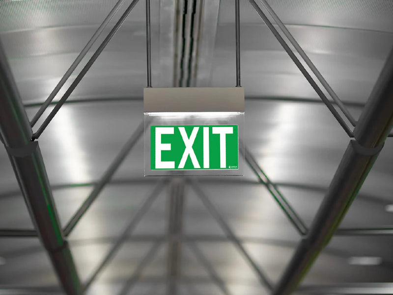 שלט EXIT ירוק מואר תלוי בתקרה בחלל מעבר